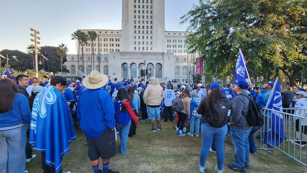 Fans in blue gather on the lawn in front of Los Angeles City Hall